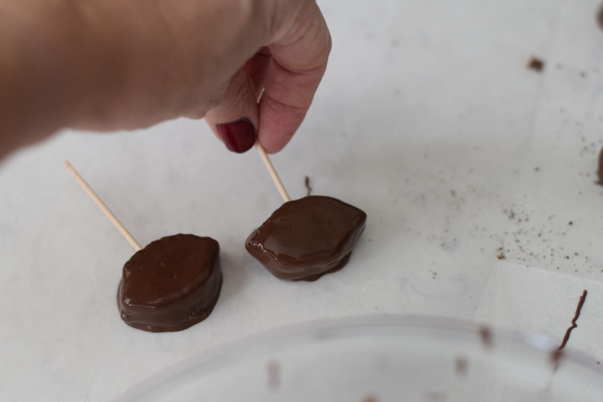 setting football Oreos down on wax paper 