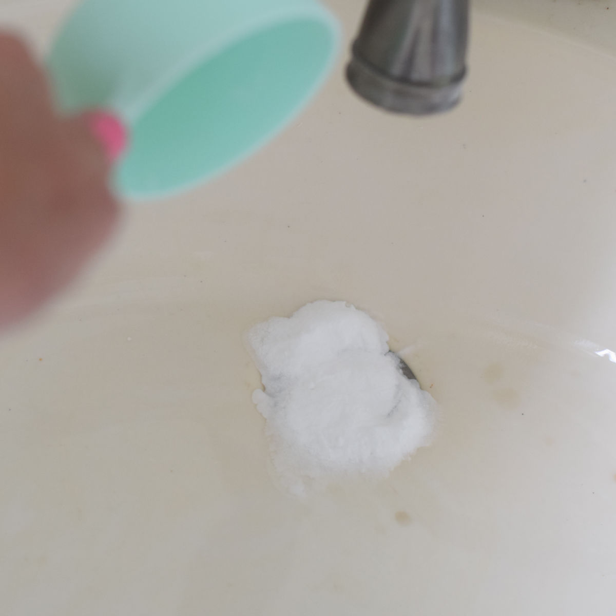 pouring baking soda into drain